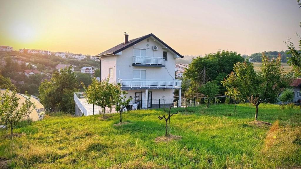 a white house on top of a grassy hill at White Villa Blažuj in Blažuj