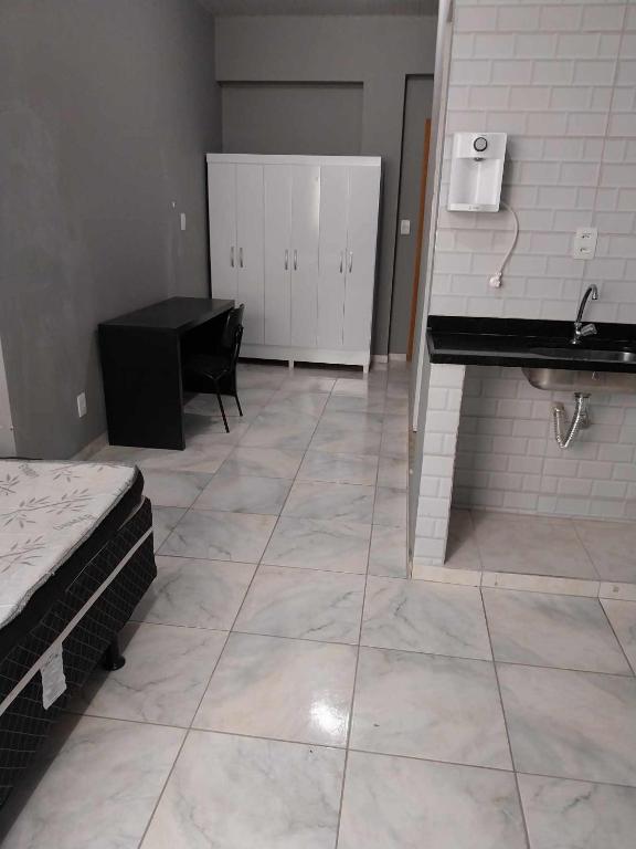 a room with a bed and a sink and a desk at KITNET ELVIS PRESLEY - Largo do Machado in Rio de Janeiro