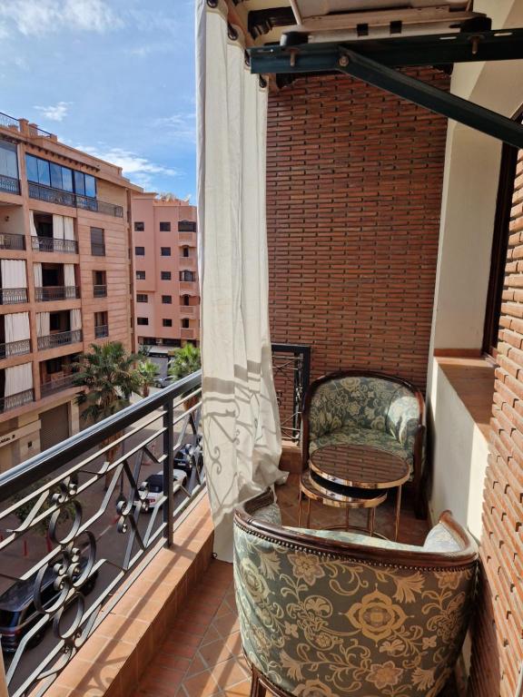 een balkon met een stoel en een tafel bij Appartement pour les séjours in Marrakesh