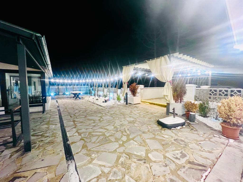 een groot terras met een stenen binnenplaats 's nachts bij M Town cotagge house 