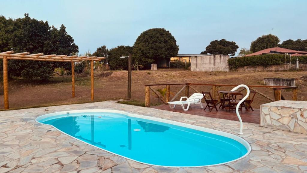 een zwembad in een tuin met een tafel en stoelen bij Chácara pôr do sol in Sorocaba