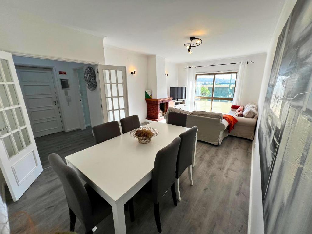 ein Wohnzimmer mit Tisch, Stühlen und Sofa in der Unterkunft Naval Beach Apartment in Azurara