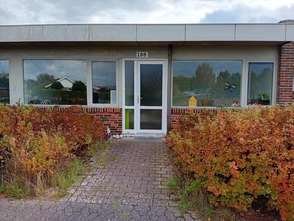 een gebouw met een deur met een bord erop bij Apartment in green area in Grindsted