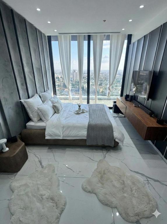 a bedroom with a bed and a large window at Sky High 15 Choose Between 2 Luxury Penthouses in Beer Sheva