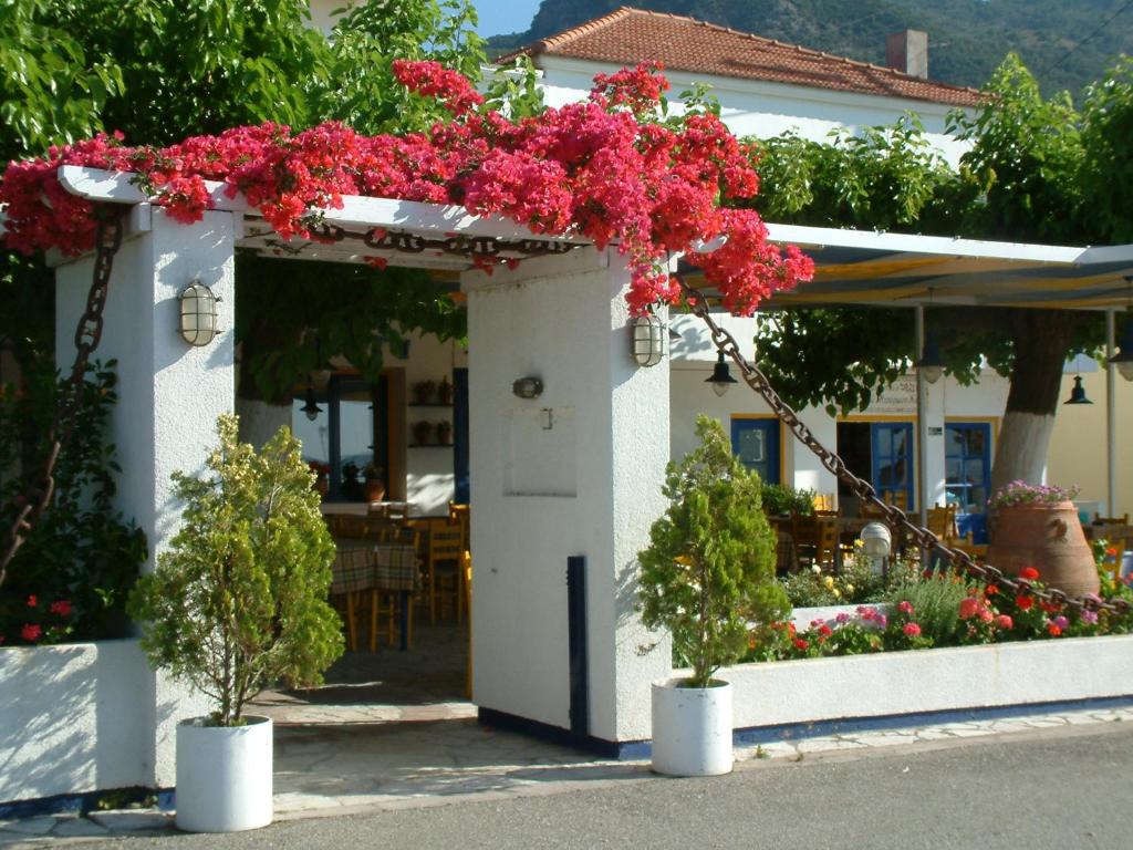 ein Gebäude mit rosa Blumen drauf in der Unterkunft Melistas Rooms in Marathias