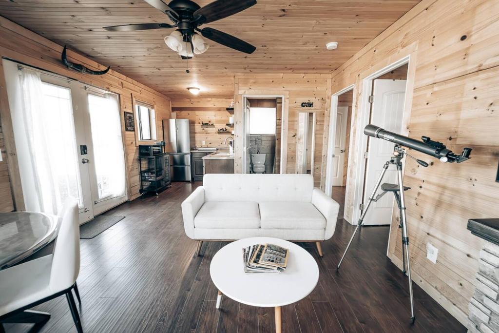 a living room with a white couch and a camera at Cozy Cub Cabin, Wilderness Retreat Williams AZ near Grand Canyon, Fire pit in Williams