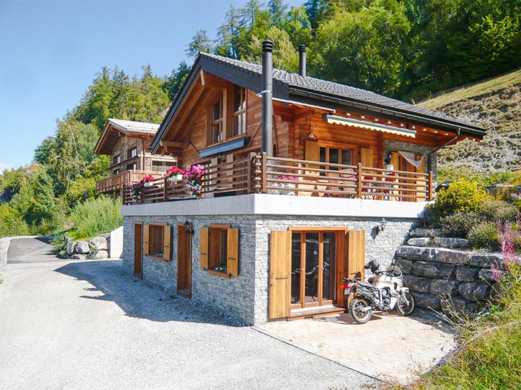a house with a motorcycle parked in front of it at FeWo im Chalet Schneeflöckli in La Tzoumaz