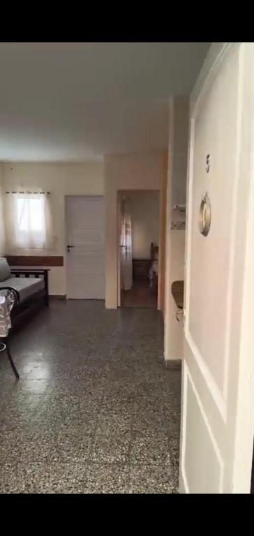 een lege woonkamer met een deur en een kamer met een bed bij PH en Mar de Ajó Centro in Mar de Ajó
