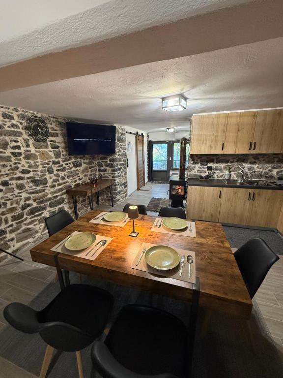 una sala da pranzo con tavolo e sedie in legno di Stone house seta a Séta