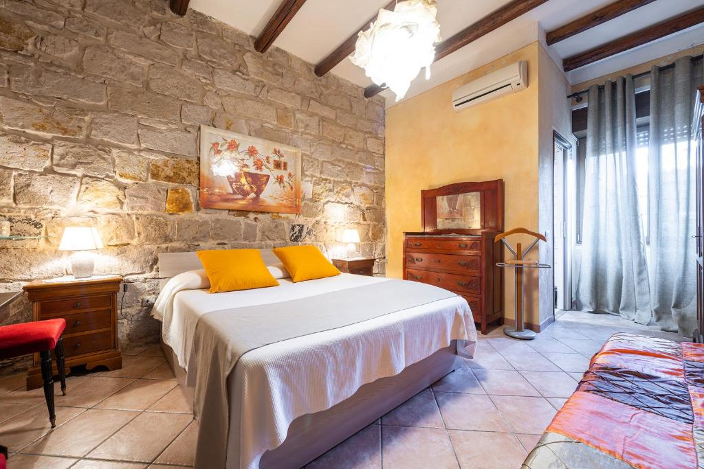 Un dormitorio con una cama y una pared de piedra. en Domus de Janas Rooms Gonnesa, en Gonnesa