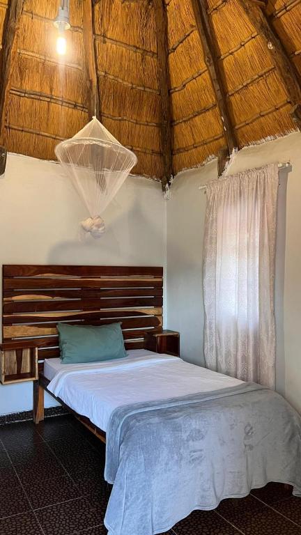 una camera da letto con un letto con testiera in legno di Edsam Lodge a Divundu