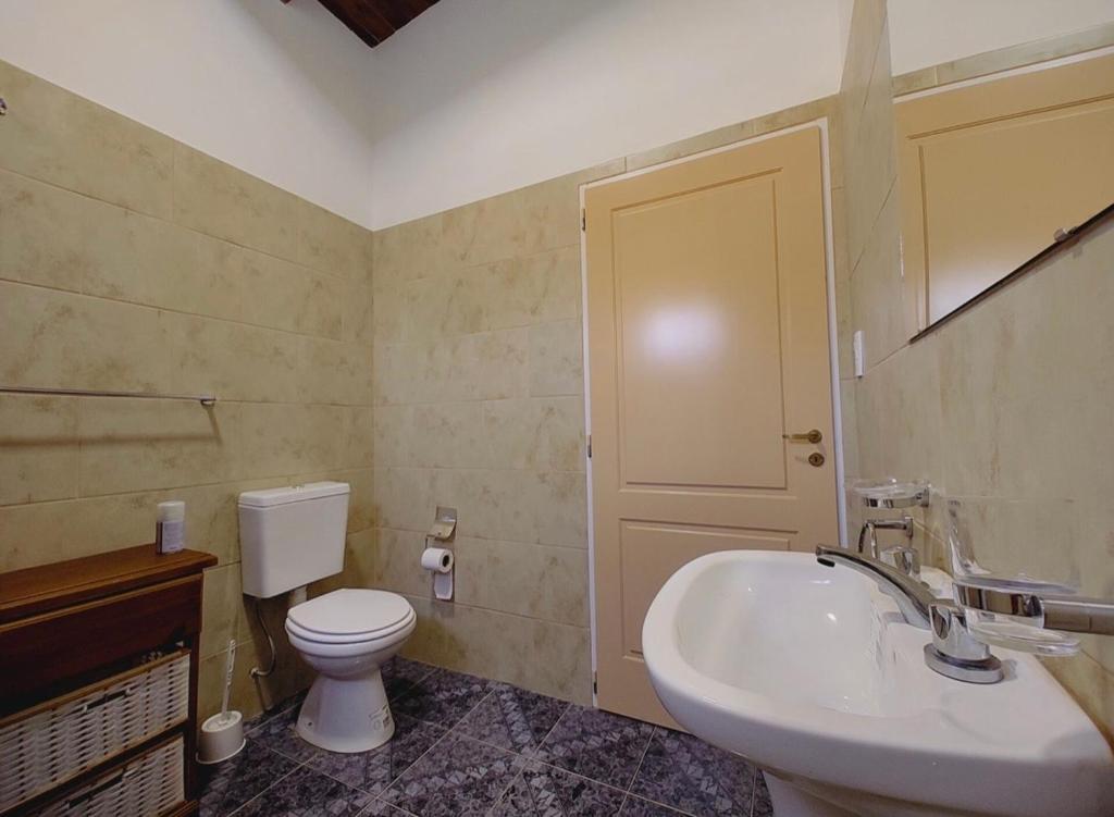 een badkamer met een wit toilet en een wastafel bij Los Fresnitos in Villa Lía