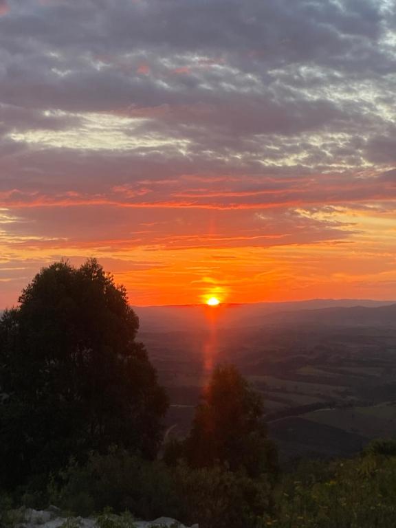een zonsondergang vanaf de top van een berg met zonsondergang bij Suíte 4 Centro de São Thomé das Letras in São Thomé das Letras