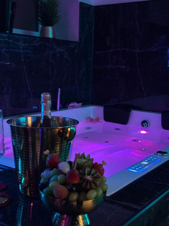 a bowl of fruit on a table with a bottle of wine at Aura Spa Herne Premium in Herne