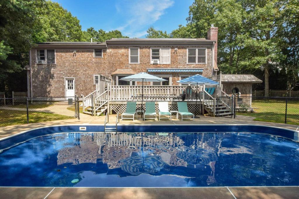 a house with a swimming pool in front of a house at Private Saltwater Pool Game Room near Beaches in Barnstable