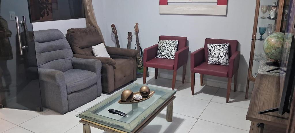 een woonkamer met stoelen en een tafel bij Cantinho da paz in Gravatá