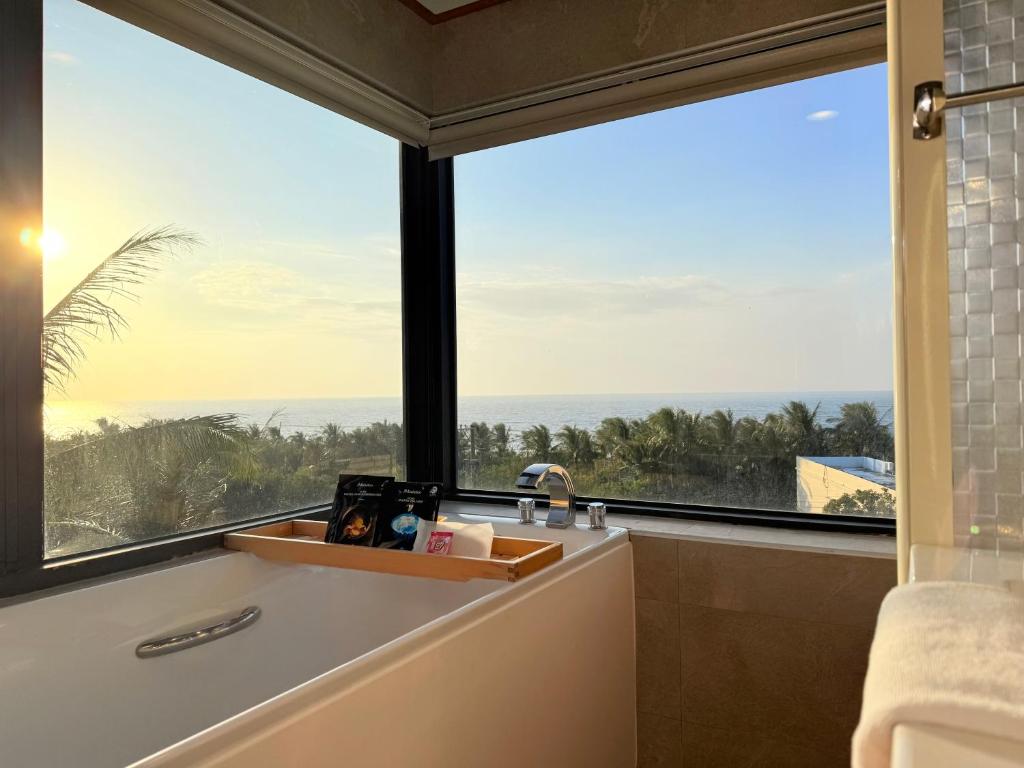 Un baño con bañera y una gran ventana. en 光隅民宿 Light Haus Inn, en Hengchun