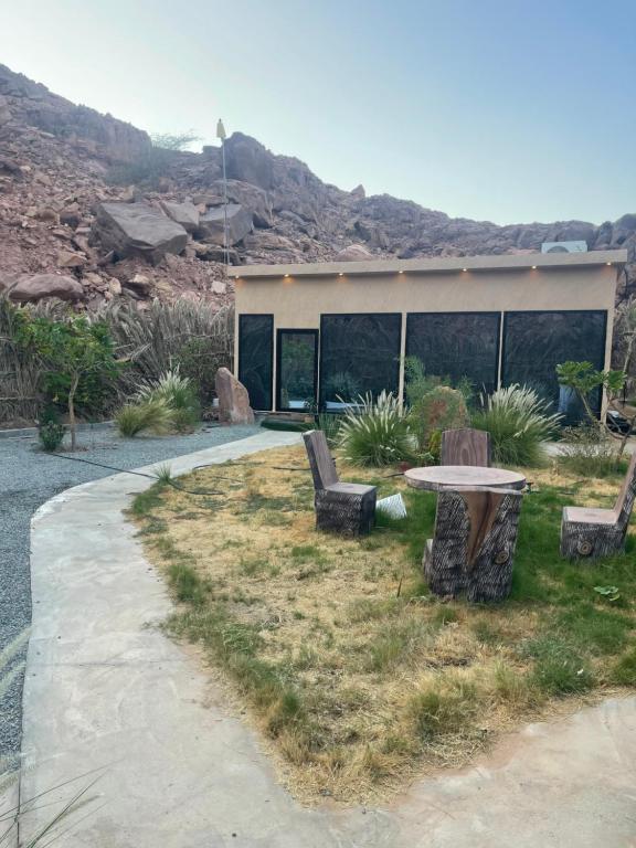 un patio con mesa y bancos frente a un edificio en شاليه نخله, en Al Ula