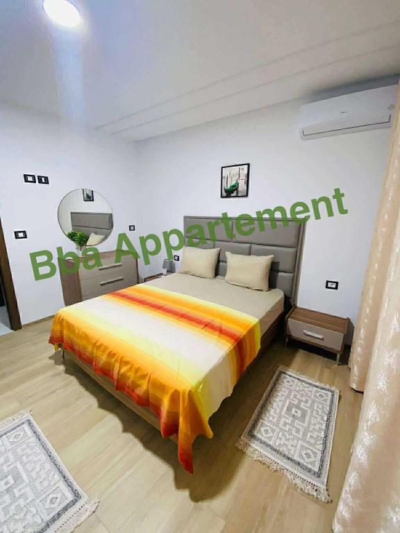 een slaapkamer met een bed met een bordje aan de muur bij Dar awina in Bin Rhilouf