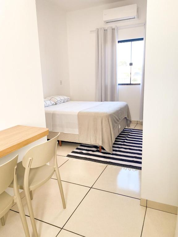 a bedroom with a bed and a table and chairs at Ap8 - Aconchegante e Completo com Ótimo Custo-Benefício in Guaíra