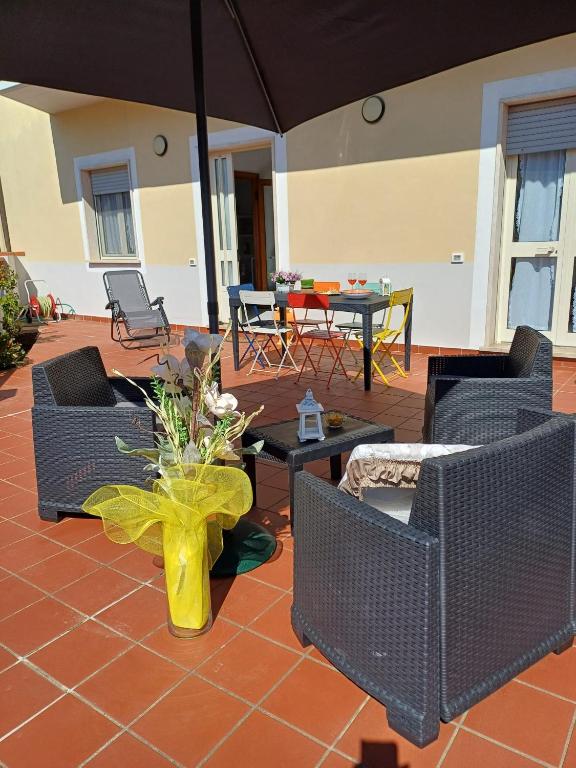 a patio with chairs and a table and an umbrella at Casa Le Camelie in Stiava