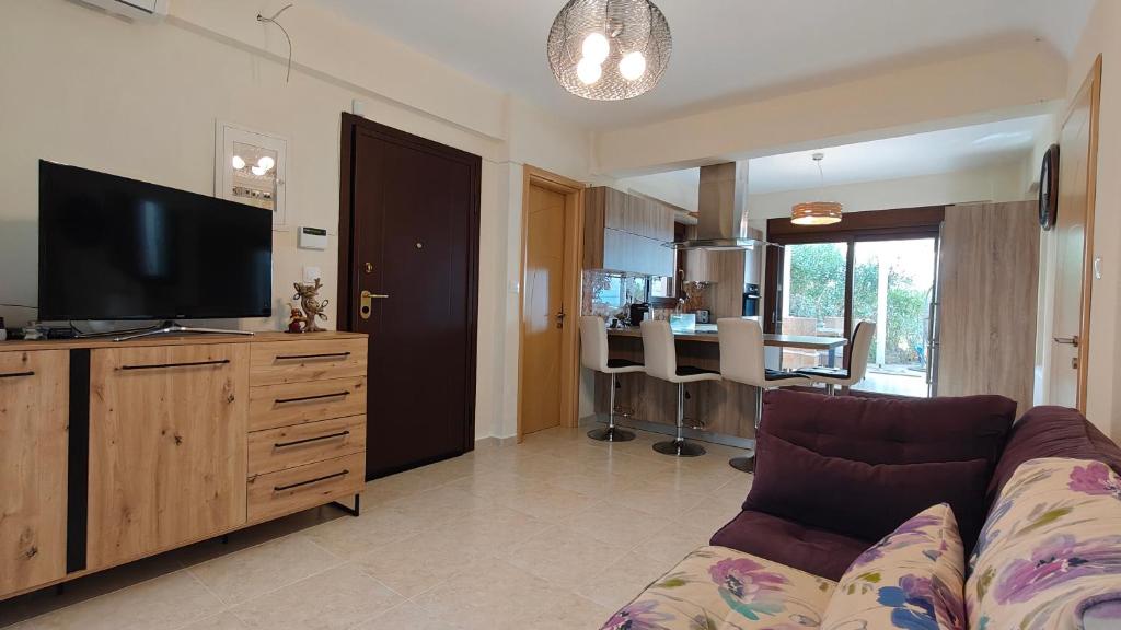 un soggiorno con divano e TV a schermo piatto di Elia Sunset a Lagomandra