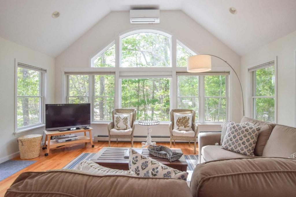 Una sala de estar con un sofá y un televisor. en 5-Mins to Forest Beach Dog Friendly, en Chatham