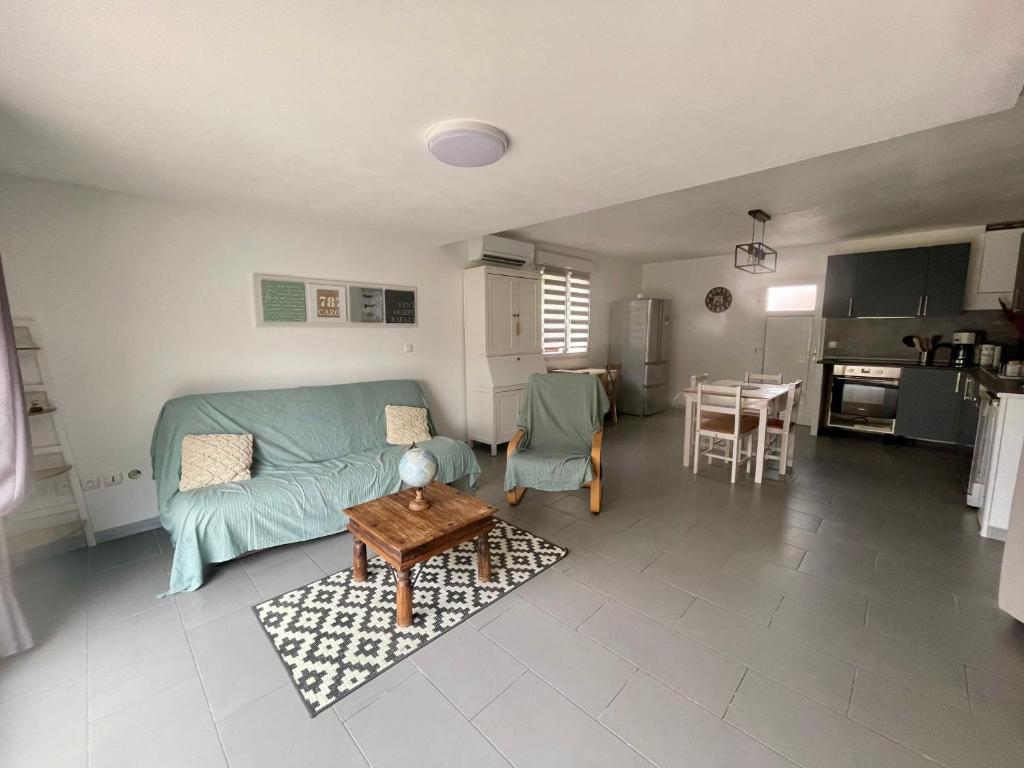 una sala de estar con un sofá y una mesa en Gite indépendant dans propriété sécurisée avec piscine, en Servian