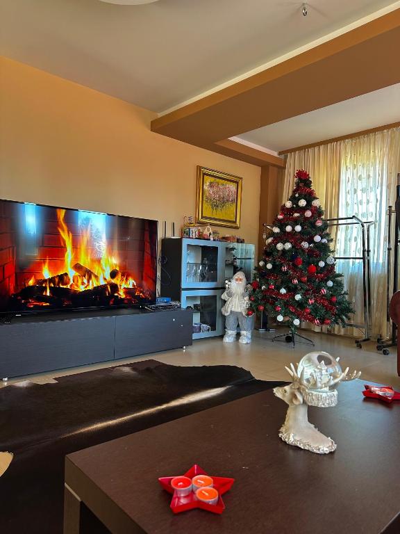 a living room with a christmas tree and a fireplace at Ava Apartment Pamporovo in Pamporovo