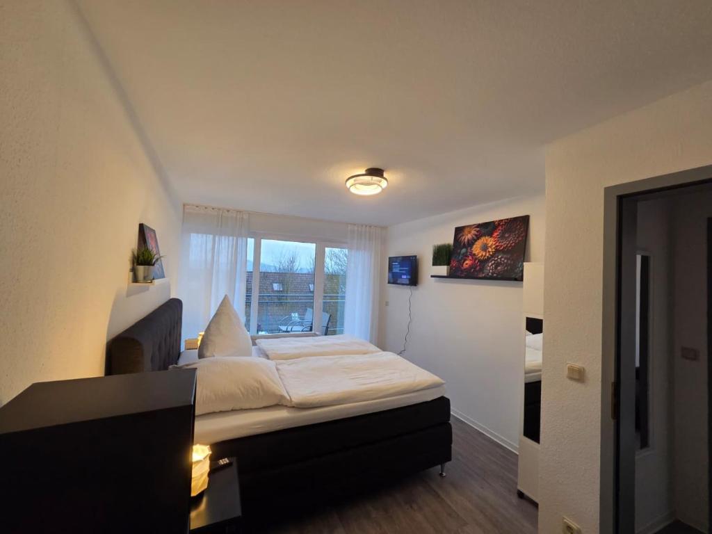 ein kleines Zimmer mit einem Bett und einem Fenster in der Unterkunft 3-room apartment with balcony in Northeim