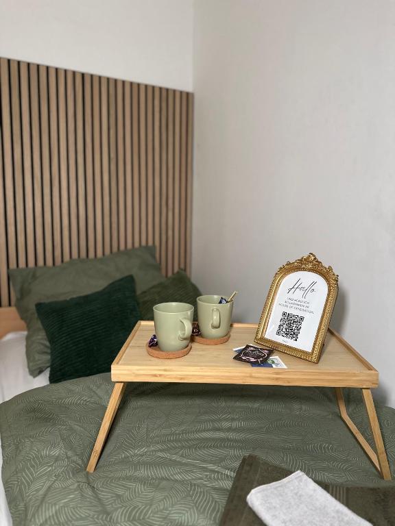 einem Tisch mit zwei Tassen auf einem Bett in der Unterkunft HouseofGeneration am Marienplatz in Stuttgart