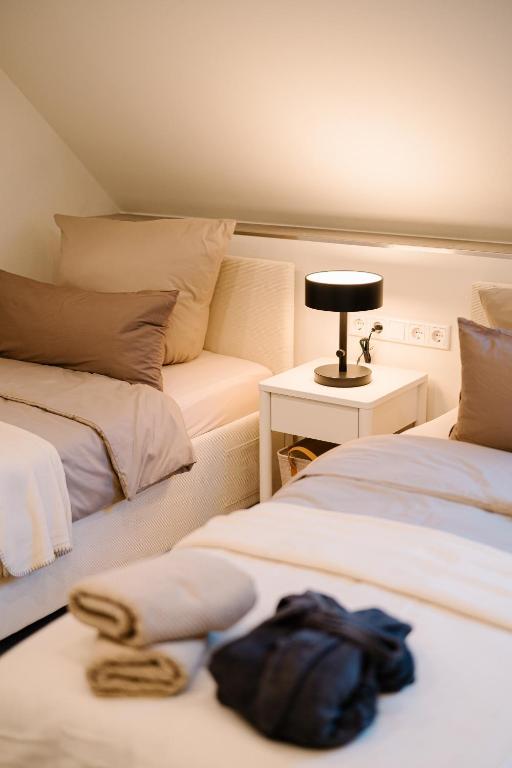 a bedroom with two beds and a table with a lamp at saGo Airporthouse in Düsseldorf