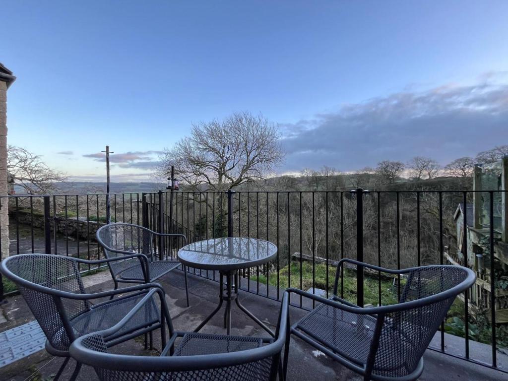 a patio with chairs and tables and a fence at Dale View in Youlgreave