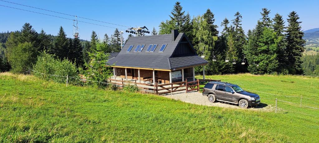 a car parked in front of a small house at Domek Na Stoku in Korbielów