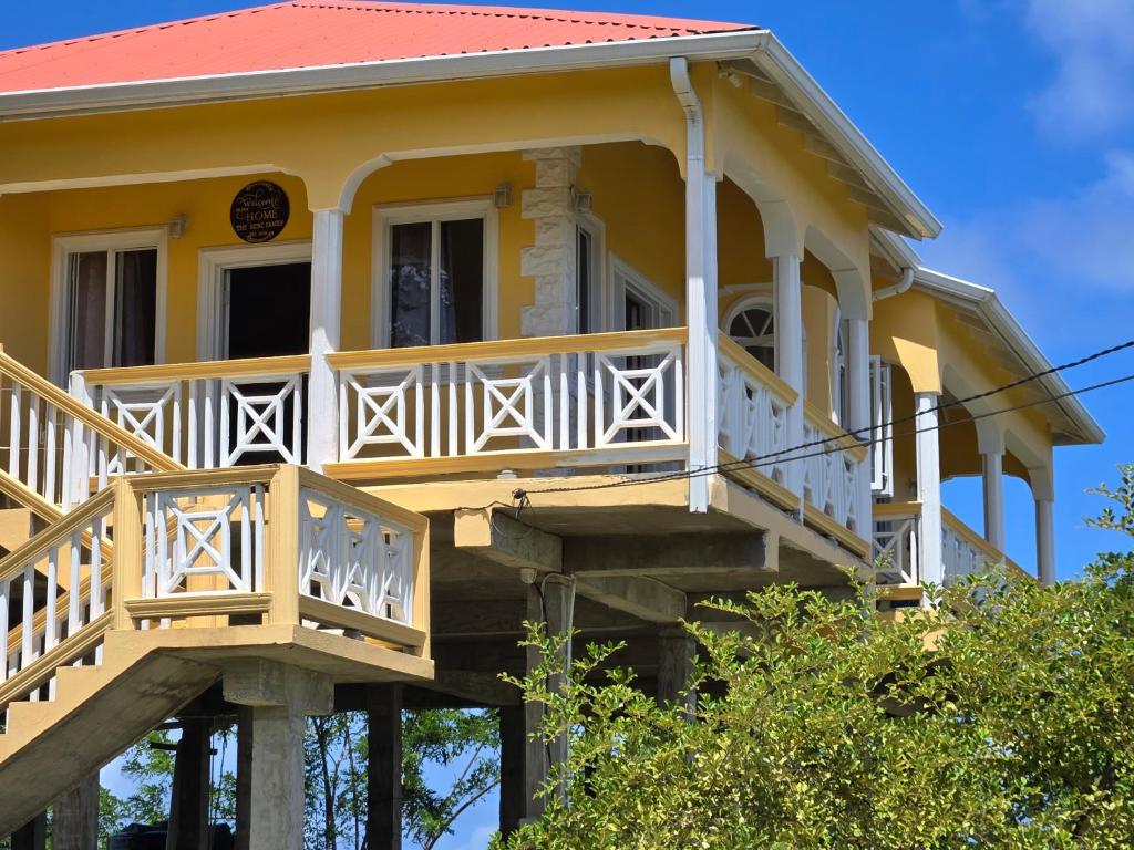 a yellow house with a balcony on top of it at Cozy Hill Vista in Micoud