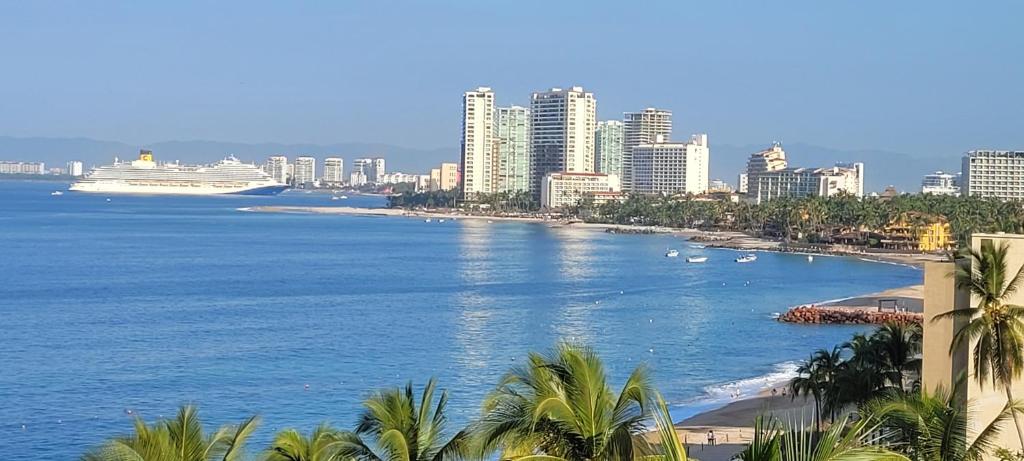 a view of a city with a cruise ship in the water at Beachfront Harbor 171 Condo Ocean View Pool, Gym WiFi in Puerto Vallarta