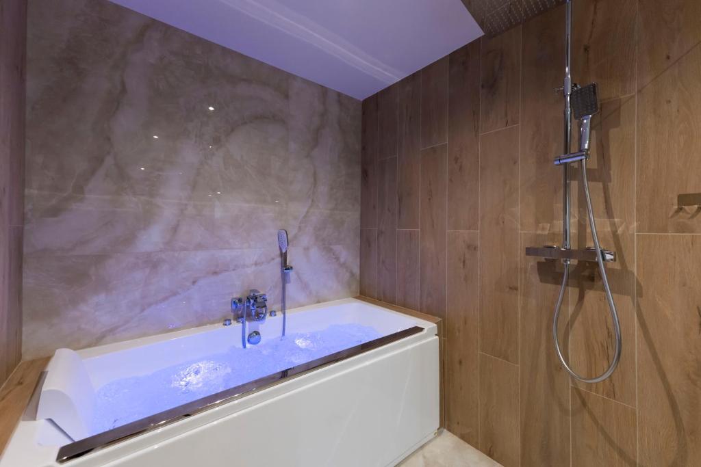 a bathroom with a shower and a tub with a sink at Spa & Relaxation 15 min de Lyon - Noomi Suite in Oullins
