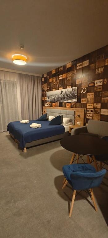 a bedroom with a bed and chairs in a room at Apartament Czarna Góra Blue in Sienna