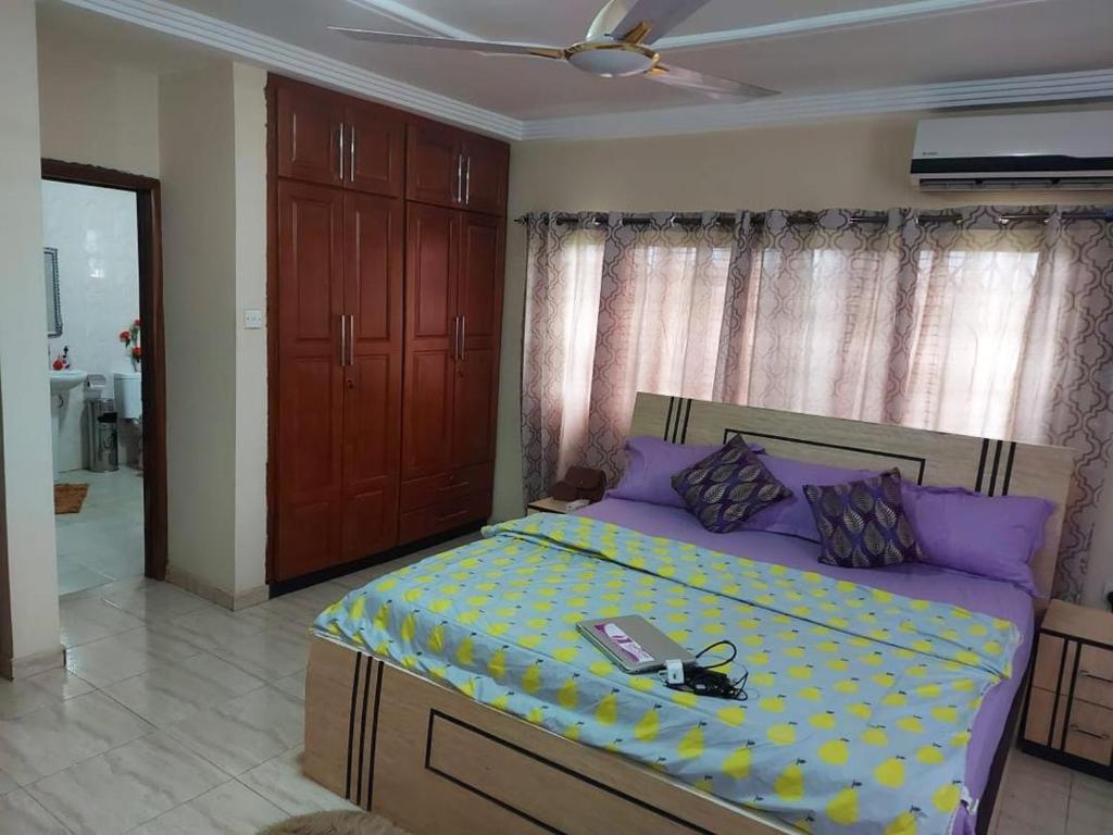 ein Schlafzimmer mit einem Bett, auf dem ein Buch liegt in der Unterkunft Osprise Residencies in Tema