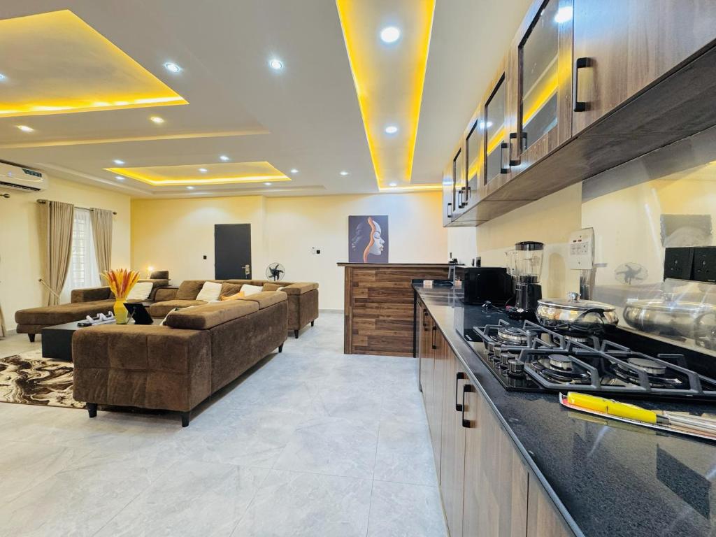 sala de estar amplia con sofás y cocina en StayatMargarets, en Abuja