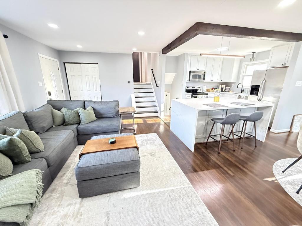 Una sala de estar con un sofá y una cocina. en Gambrills Modern Retreat near Annapolis & Ft Meade, en Gambrills