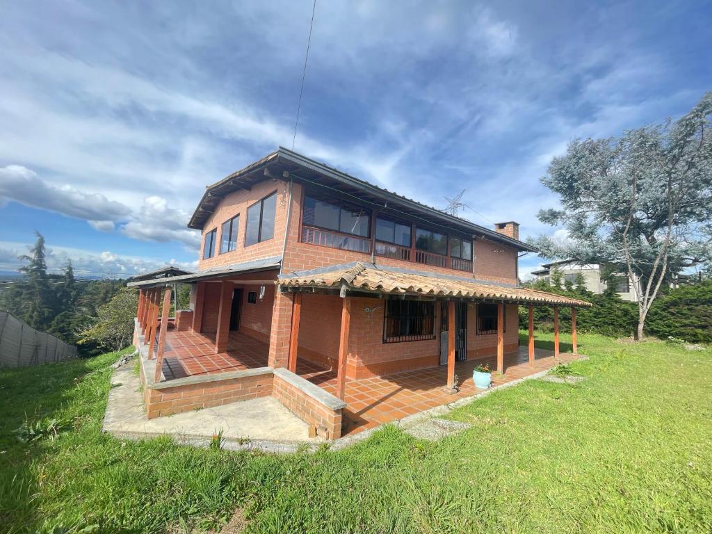 メデジンにあるSerene Soul Arroyaveの緑の畑の上に座る家