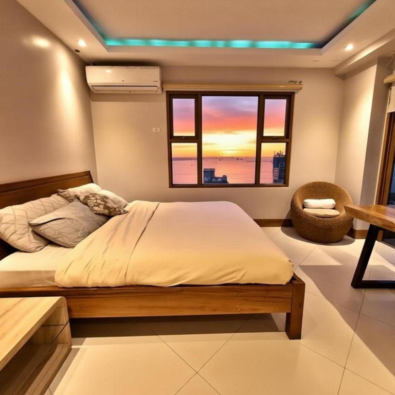a bedroom with a large bed and a window at STAYLUXIA MANILABAYVIEW - FEATURING 1 - 5 BEDROOM SUITES WITH BALCONY POOL BAYVIEWS NETFLIX - Housekeeping Available- in Manila