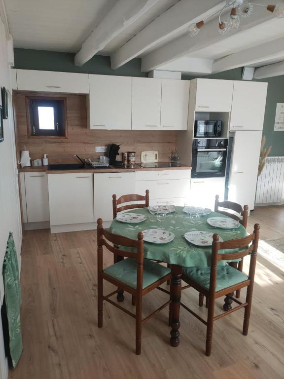 a kitchen with a table and chairs in a room at Le gîte des Bernadettes in Apchat