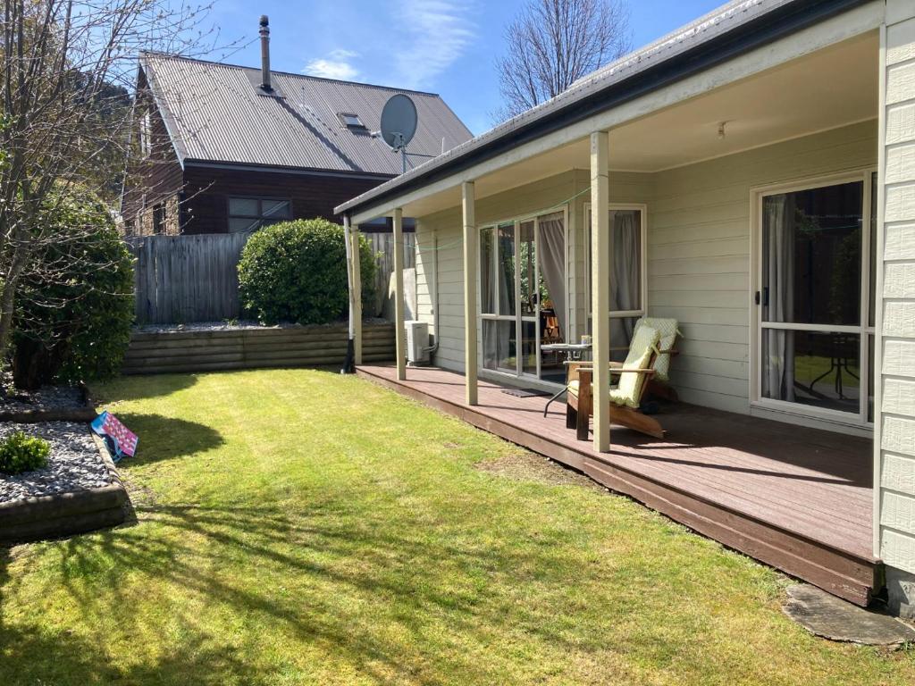 une terrasse couverte d'une maison avec une pelouse dans l'établissement 42b Conical Hill Road, à Hanmer Springs