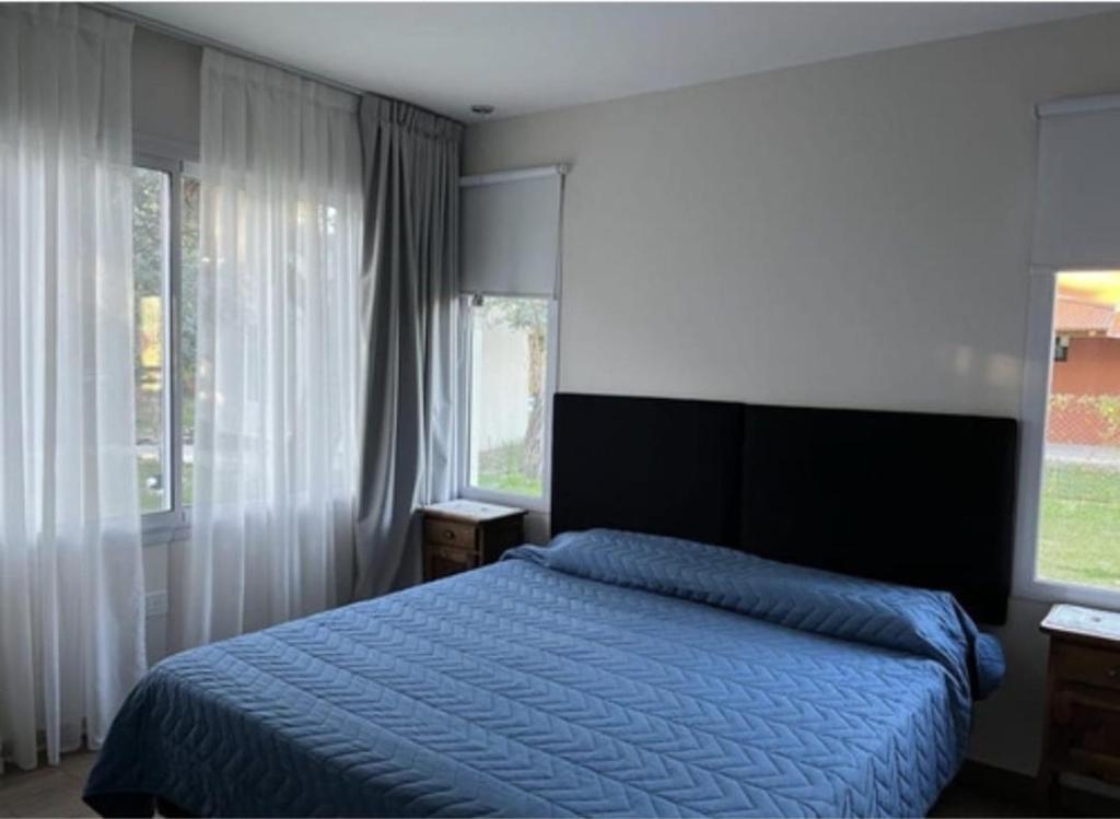 1 Schlafzimmer mit einem blauen Bett und 2 Fenstern in der Unterkunft Casa de campo LA MOROCHA in San Pedro