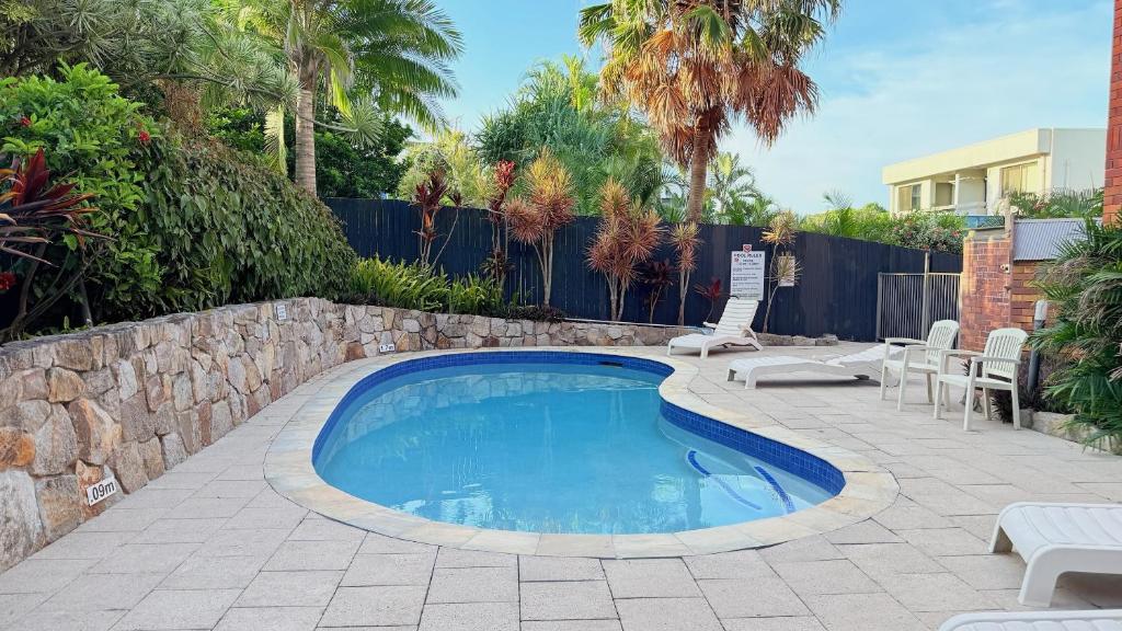 een zwembad op een patio met stoelen en een hek bij 2Bdr Beachfront Apartment - First Bay Coolum in Coolum Beach