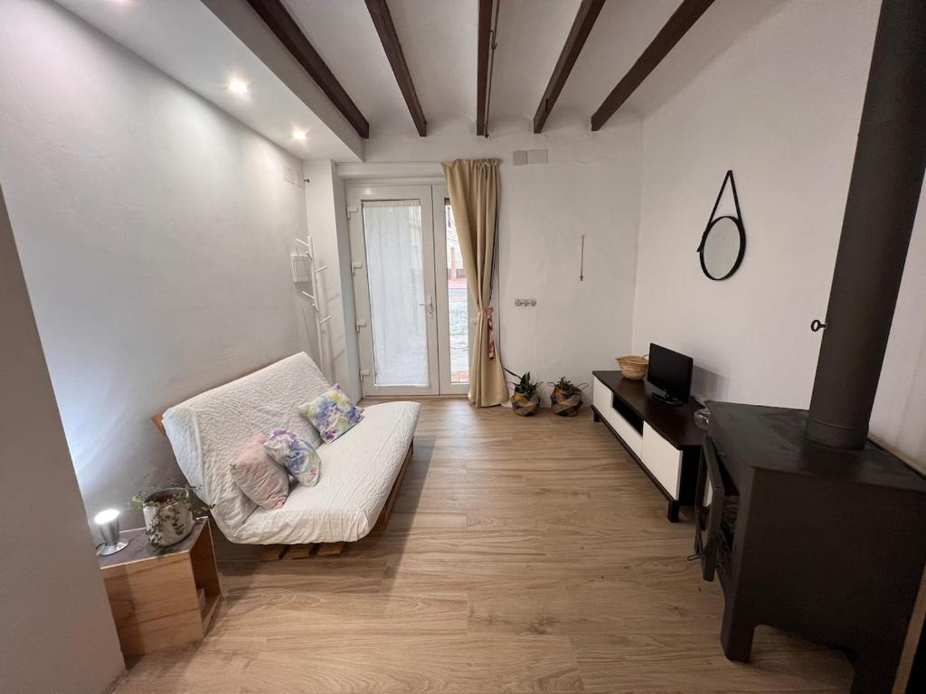 a living room with a white couch and a television at Restored house near Valencia in Simat de Valldigna