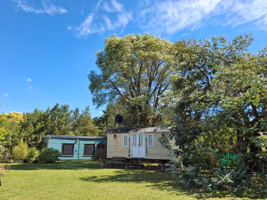 een oude caravan op een erf met een boom bij Las Nativas de Areco in San Antonio de Areco