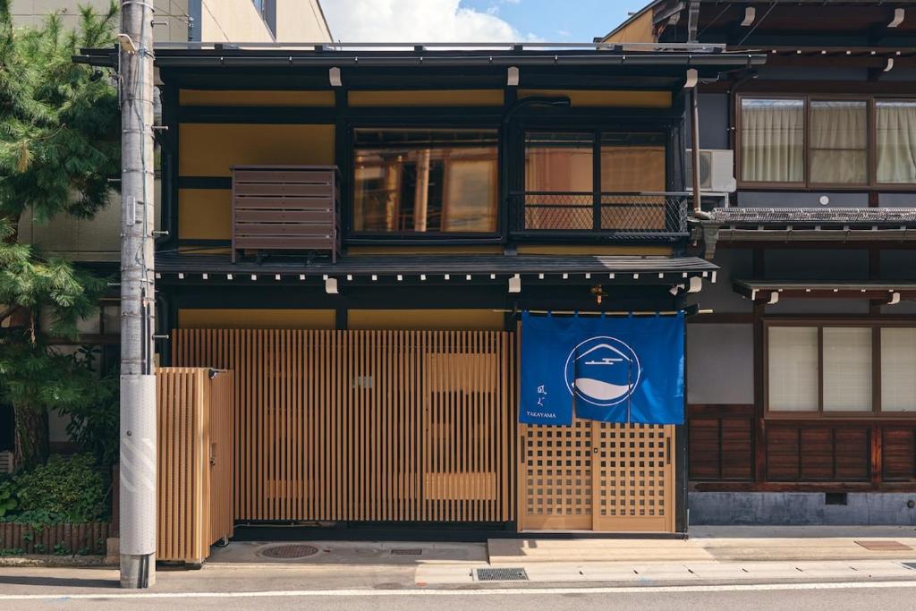 un edificio con un cartello blu sul lato. di 御宿 凪ぐ Takayama a Wada